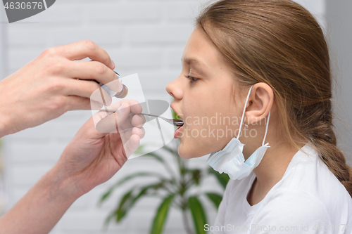 Image of Eleven-year-old girl with a spoon is given liquid potion