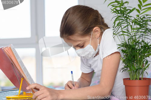 Image of A sick girl teaches homework and does homework
