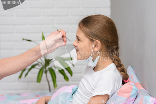 Image of A recovering girl was given another medicine from a spoon