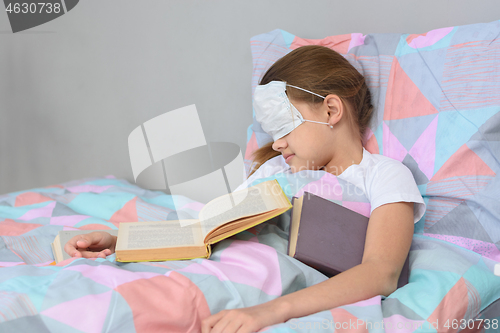 Image of The sick girl fell asleep lying in bed and pulled the mask over her face