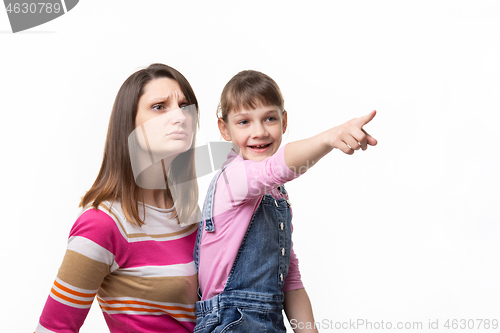 Image of Happy girl shows something to mom with finger, isolated on white background