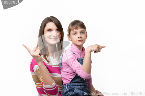 Image of The girl joyfully points a finger in one direction, the girl is sad in the other