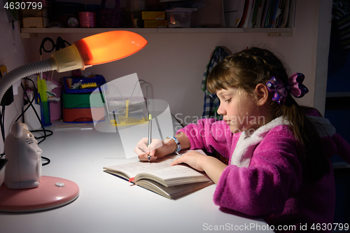 Image of A girl does homework late at night