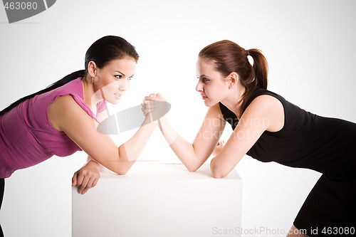 Image of Two businesswomen arm wrestling