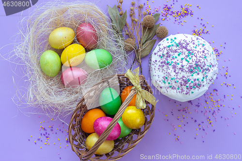 Image of multi-colored Easter eggs in a basket and nest view from above