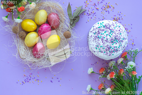 Image of pattern of Easter eggs in the nest and Easter cake on a purple background