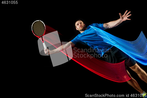 Image of one caucasian man playing tennis player on black background