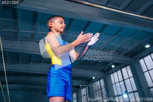 Image of beautiful boy is engaged in sports gymnastics on a parallel bars