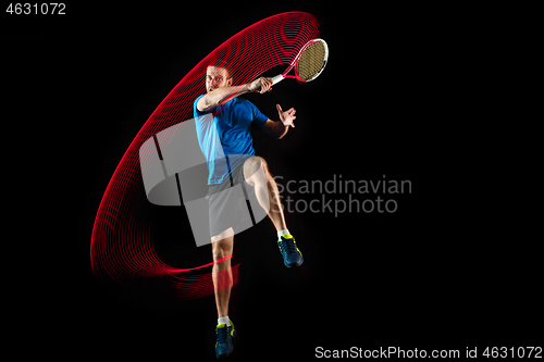 Image of one caucasian man playing tennis player on black background