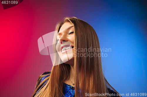 Image of The happy woman standing and smiling against colored background.