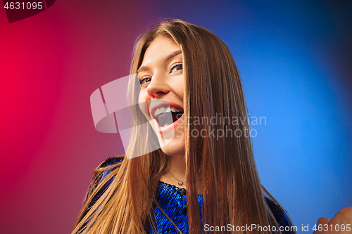 Image of The happy woman standing and smiling against colored background.