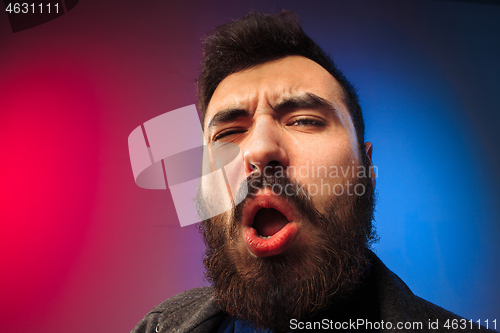 Image of Young man with disgusted expression repulsing something