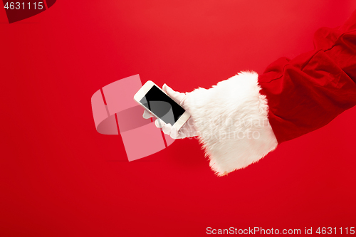 Image of Santa Claus holding mobile smartphone ready for Christmas time