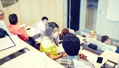 Image of group of students with notebooks at lecture hall