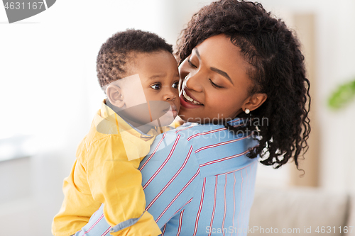 Image of happy african american mother with baby at home