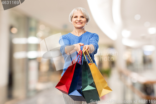 Image of senior woman with shopping bags over mall