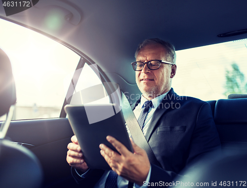 Image of senior businessman with tablet pc driving in car