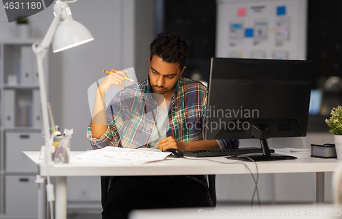 Image of creative man with papers working at night office