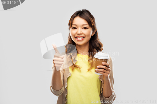 Image of asian woman drinking coffee and showing thumbs up