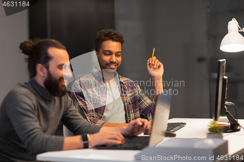 Image of creative team with computer working late at office