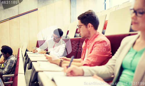 Image of group of students with notebooks in lecture hall