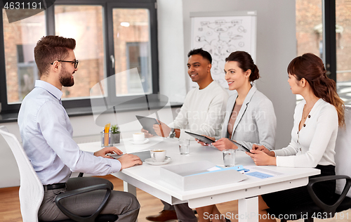 Image of recruiters having job interview with male employee