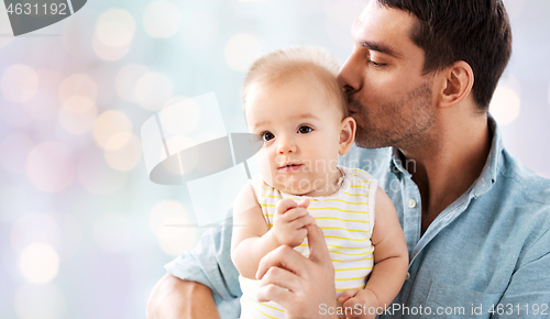 Image of father kissing little baby daughter