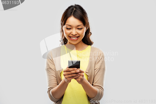 Image of happy asian woman using smartphone