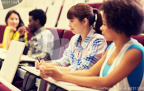 Image of group of students talking in lecture hall