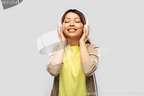 Image of asian woman in headphones listening to music