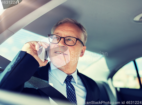 Image of senior businessman calling on smartphone in car