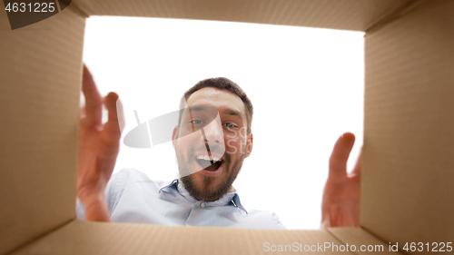 Image of smiling man taking something out of parcel box