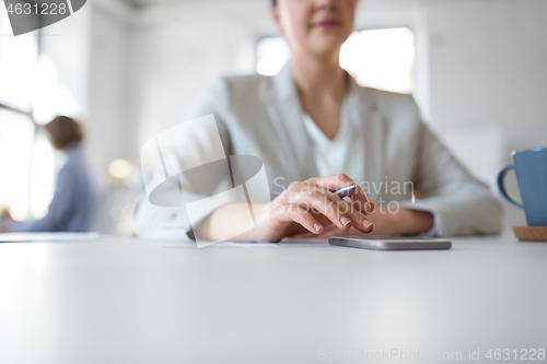 Image of businesswoman using smartphone at office