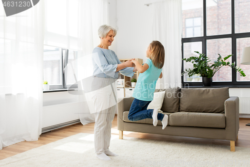 Image of grandmother and granddaughter having fun at home