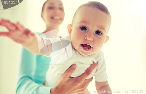 Image of happy young mother with little baby at home