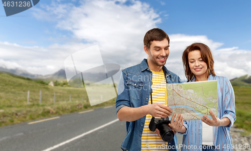 Image of happy couple of tourists with map and camera