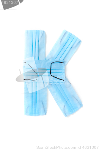 Image of Letter K made from protective medical masks on a white background.