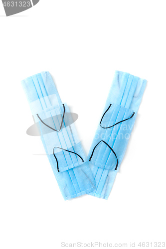 Image of Letter V made from protective medical masks on a white background.