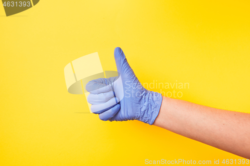 Image of Sign OK made of woman\'s hand in rubber protective glove.