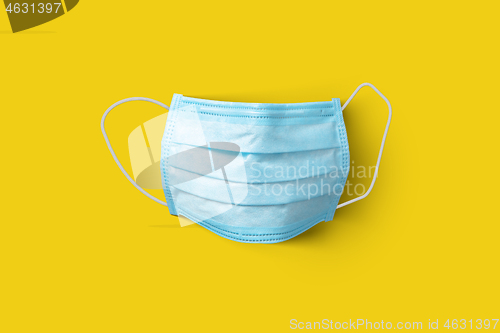 Image of Medical protective mask on a yellow background. Top view.