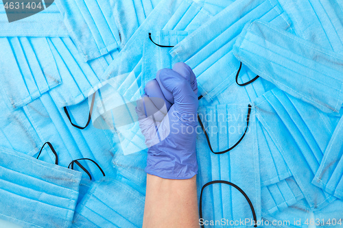 Image of Woman clenched fist in a rubber protective glove on a medical ma