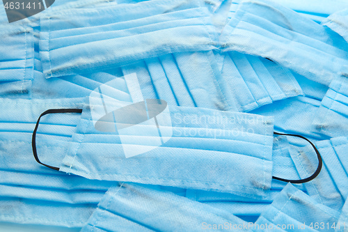 Image of Chaotic heap from blue protective medical masks. Top view.
