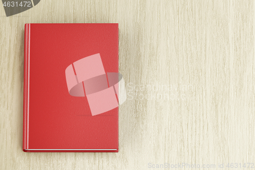 Image of Red book on wood background