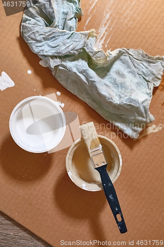 Image of Paint brush on a can of white wall paint