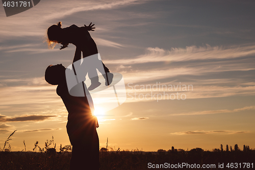 Image of Father and son playing in the park at the sunset time.