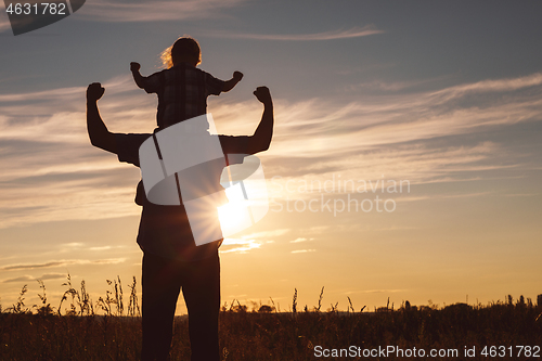 Image of Father and son playing in the park at the sunset time.