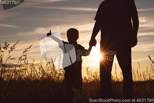 Image of Father and son playing in the park at the sunset time.