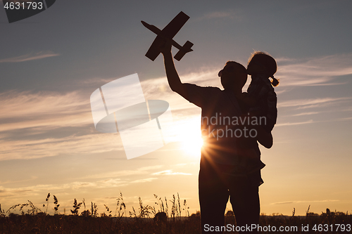 Image of Father and son playing in the park at the sunset time.