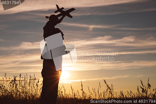 Image of Father and son playing in the park at the sunset time.