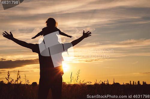 Image of Father and son playing in the park at the sunset time.